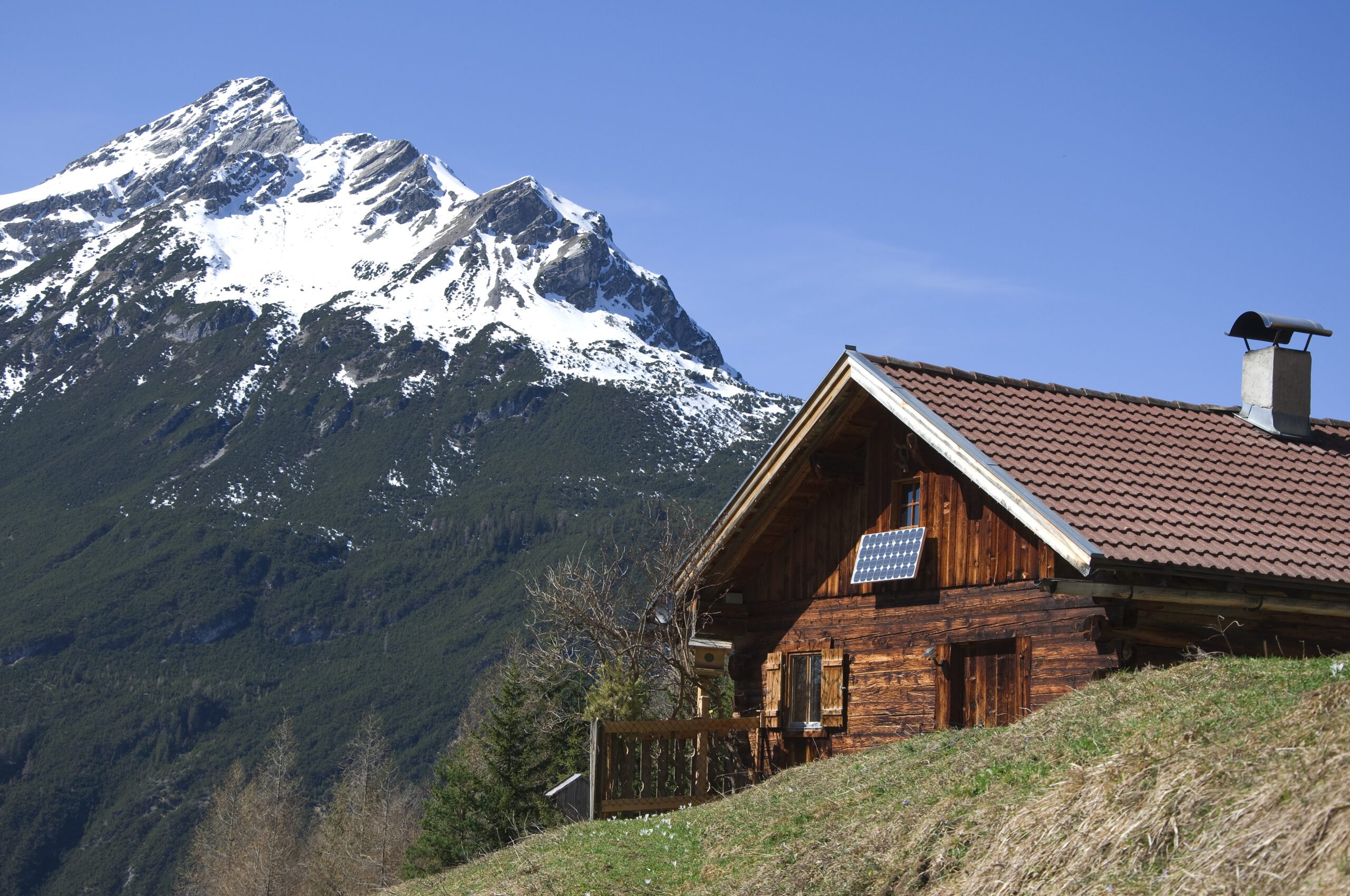 A log cabin in the snowy mountains, powered by remote solar panels