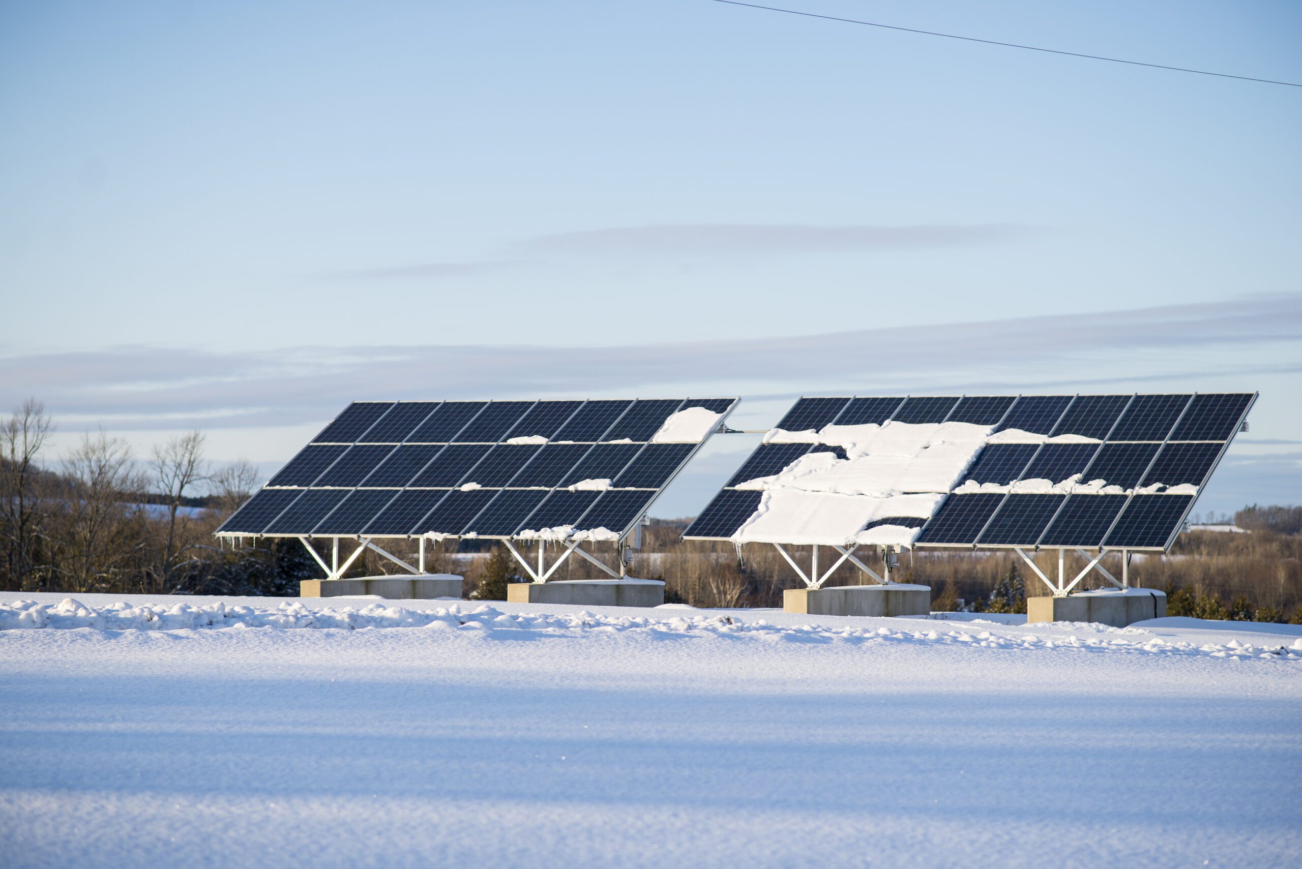 Two rural solar panels with snow on them, supporting an off-grid home in Canada.